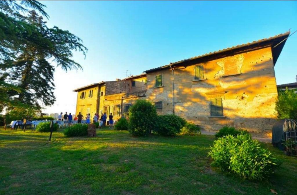 an old building with people standing outside of it at Agriturismo Le Ginestruzze in Montespertoli