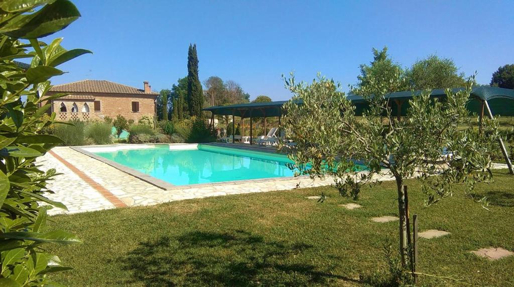 a swimming pool in a yard next to a house at Villa Nobile Cortona B&B in Cortona