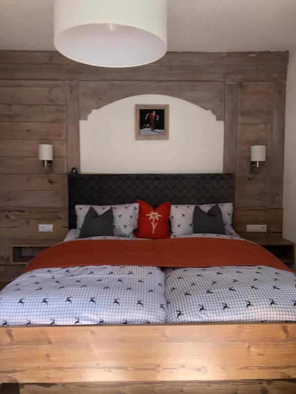 ein Schlafzimmer mit einem großen Bett mit roten und schwarzen Kissen in der Unterkunft Haus am Wald in Neustift im Stubaital