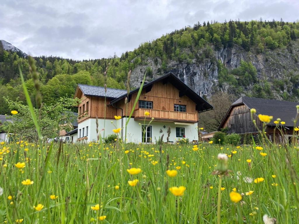 a house in the middle of a field of flowers at Egglmeier's Ferienwohnung in Grundlsee