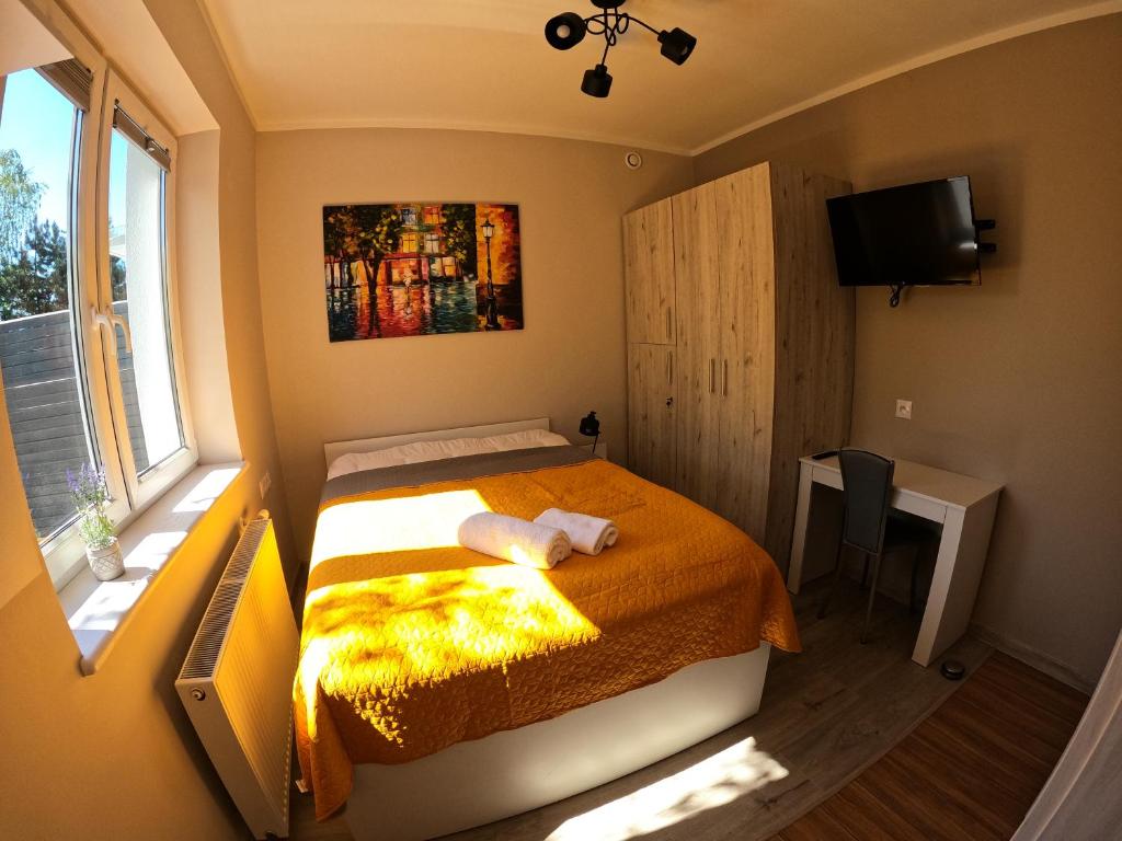 a small bedroom with a bed and a window at Noclegi na Wspólnej in Słupca