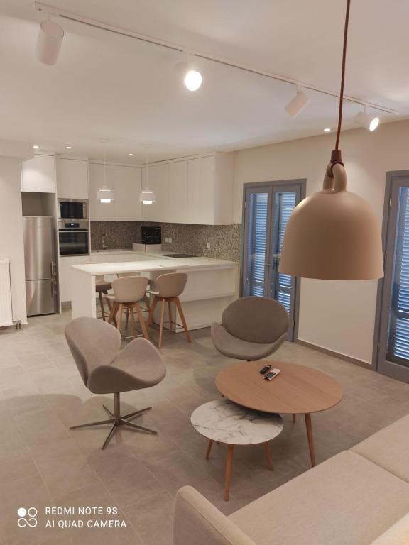 a living room with a table and chairs and a kitchen at Pink rose luxury and comfort apartment at the centre of Preveza in Preveza