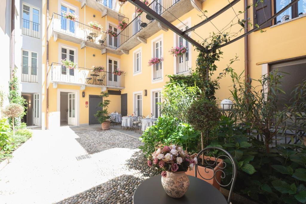 坎諾比奧的住宿－Antico Borgo B&B，一座庭院,在一座建筑里,花瓶放在桌子上