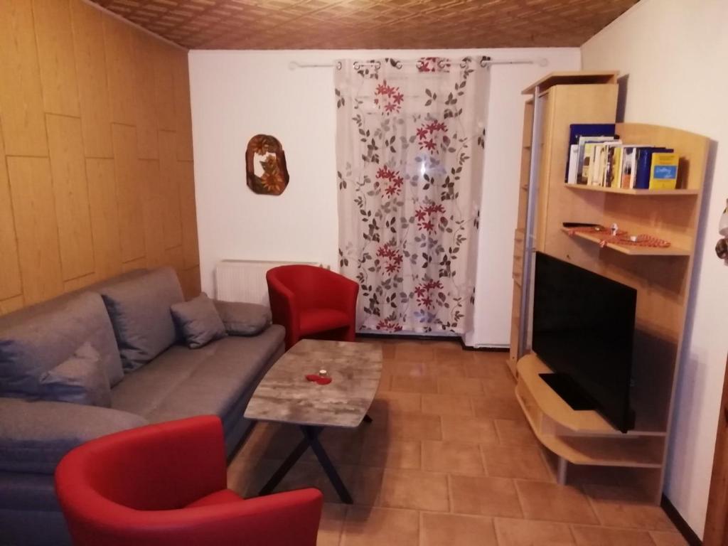 a living room with a couch and red chairs at Ferienwohnung Kleine Seite 16 in Görlitz
