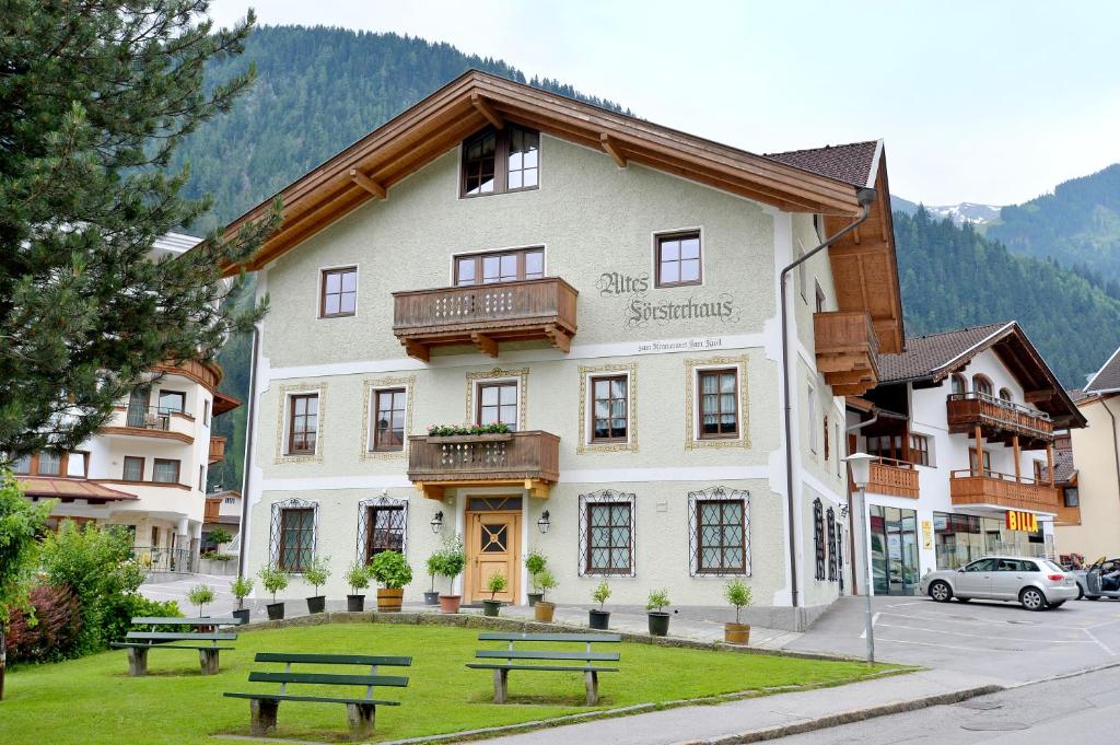 een gebouw met twee banken ervoor bij Försterhaus & Haus Andrea in Mayrhofen