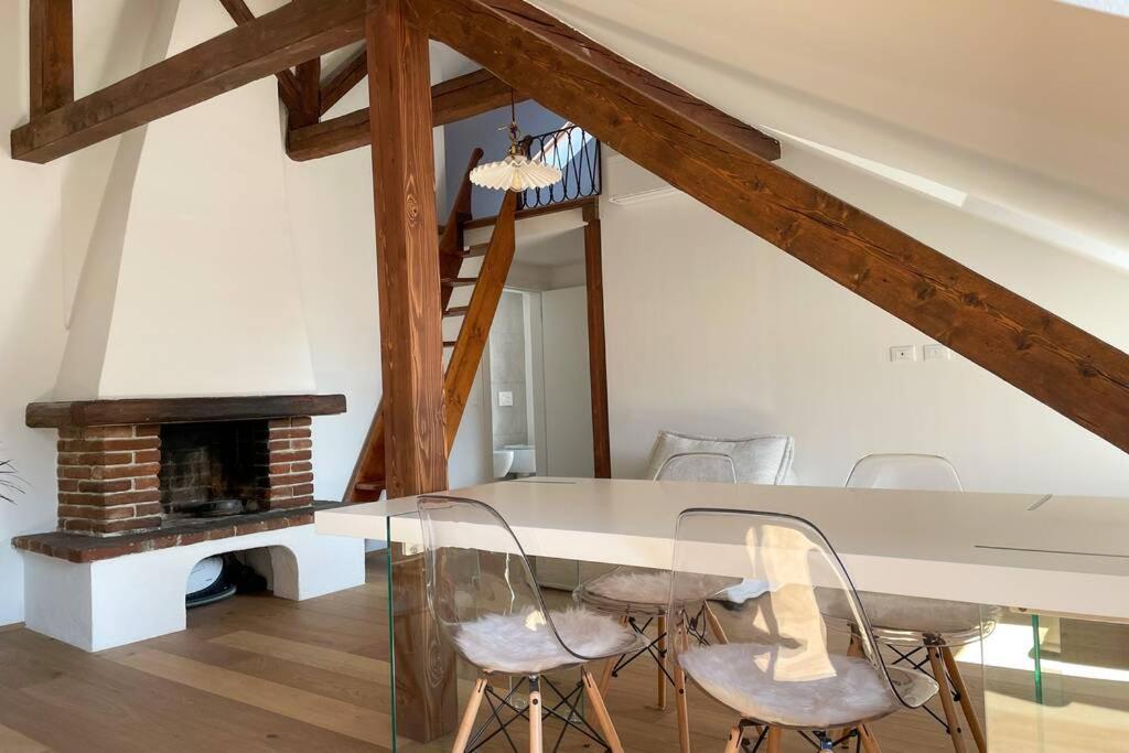 ein Esszimmer mit einem Tisch, Stühlen und einem Kamin in der Unterkunft Design Apartment in the heart of Bolzano in Bozen