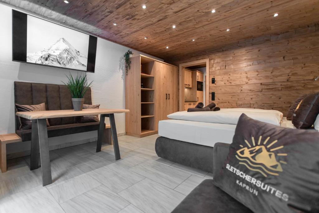 - une chambre avec un lit et un mur en bois dans l'établissement Gletschersuite - KITZSTEINHORN, à Kaprun