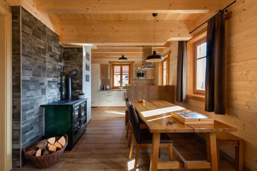 a kitchen with a wooden table and a fireplace at Arlitscherhof Ferienwohnungen und Chalets in Bad Eisenkappel