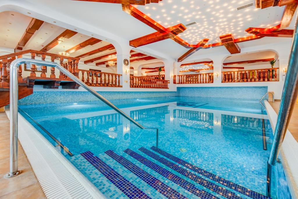 a large indoor swimming pool with blue water at Vila Miorita in Poiana Brasov