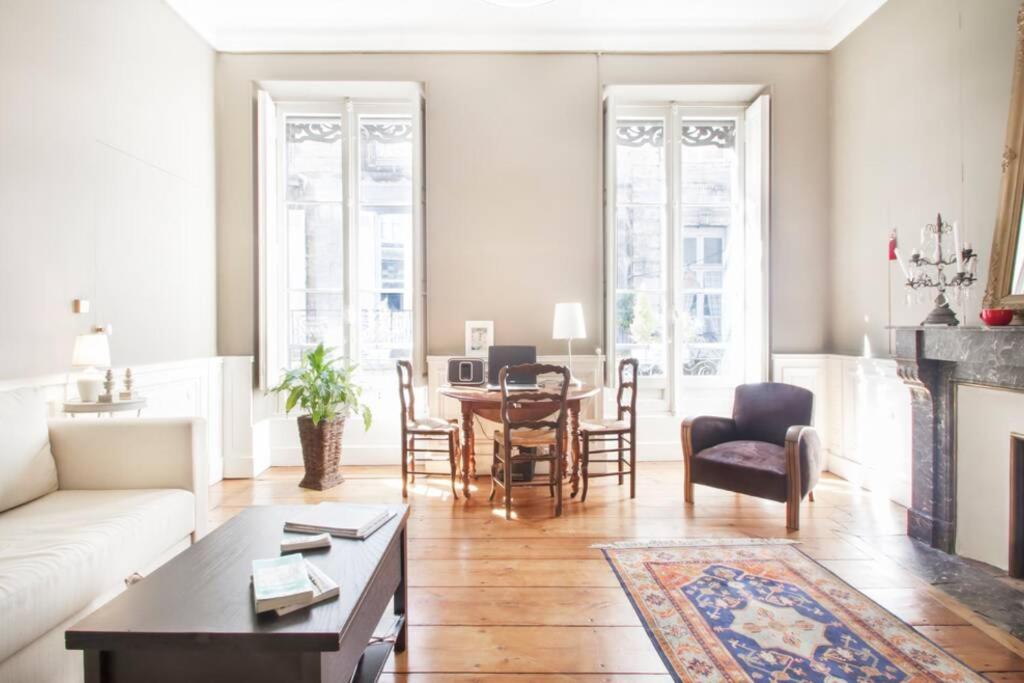 un salon avec un canapé, une table et des chaises dans l'établissement au cœur du quartier historique, à Bordeaux