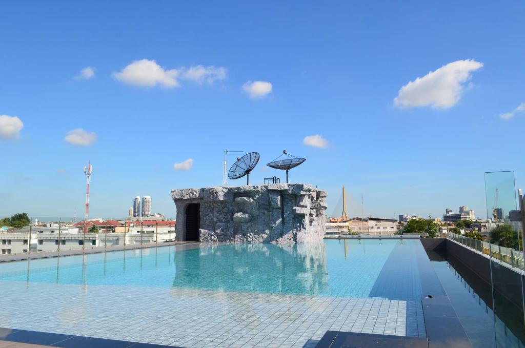 A rooftop pool with a stone waterfall feature and wide city views.