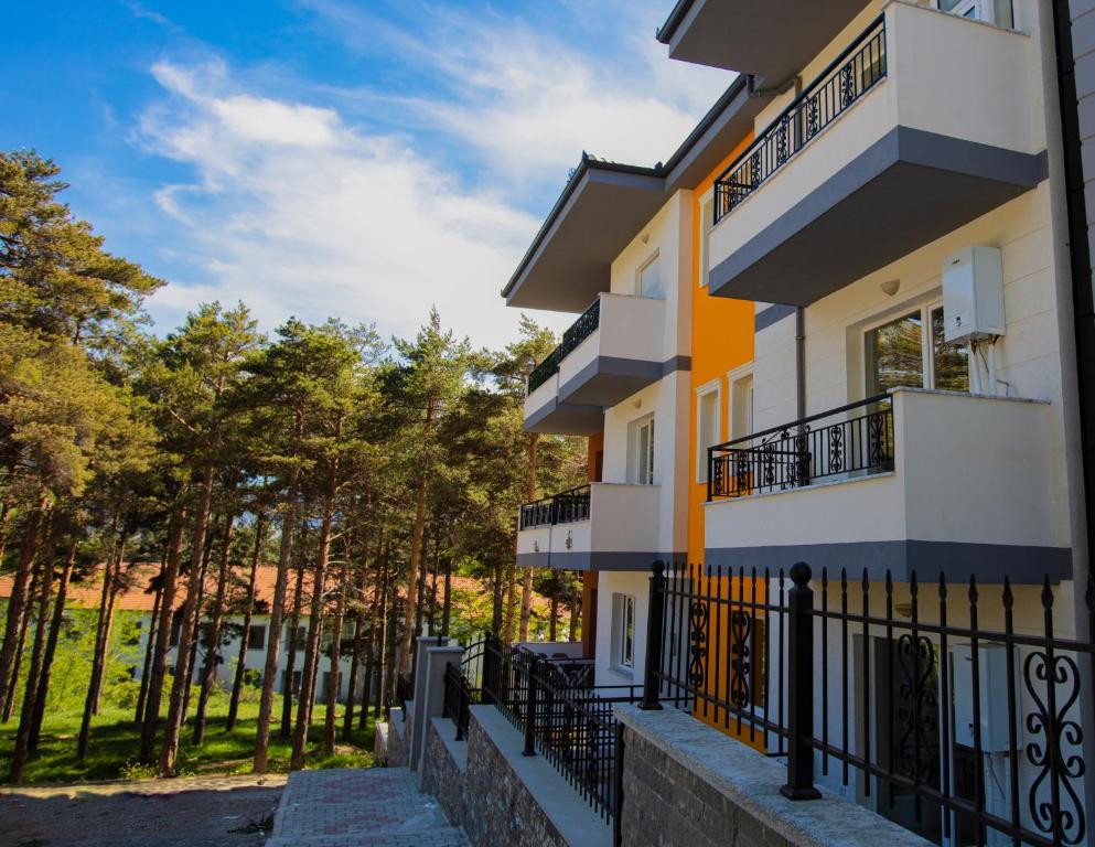 un bâtiment avec des balcons et des arbres en arrière-plan dans l'établissement Korca Apartments, à Korçë