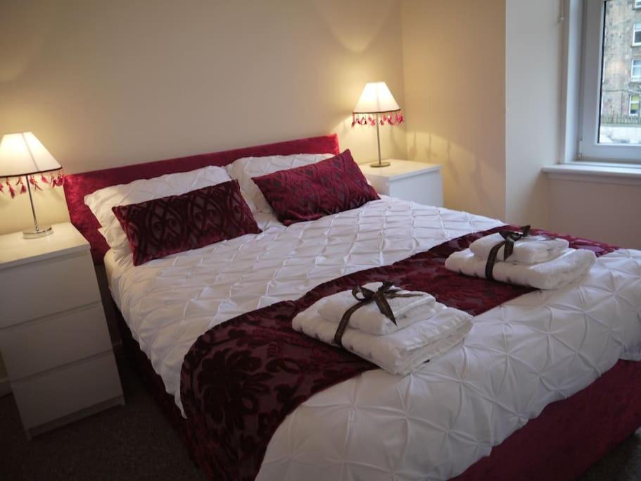 a bedroom with a large bed with towels on it at Fabulous location, One Bedroom West End Flat, just off Byres rd, close to SEC & Hydro in Glasgow