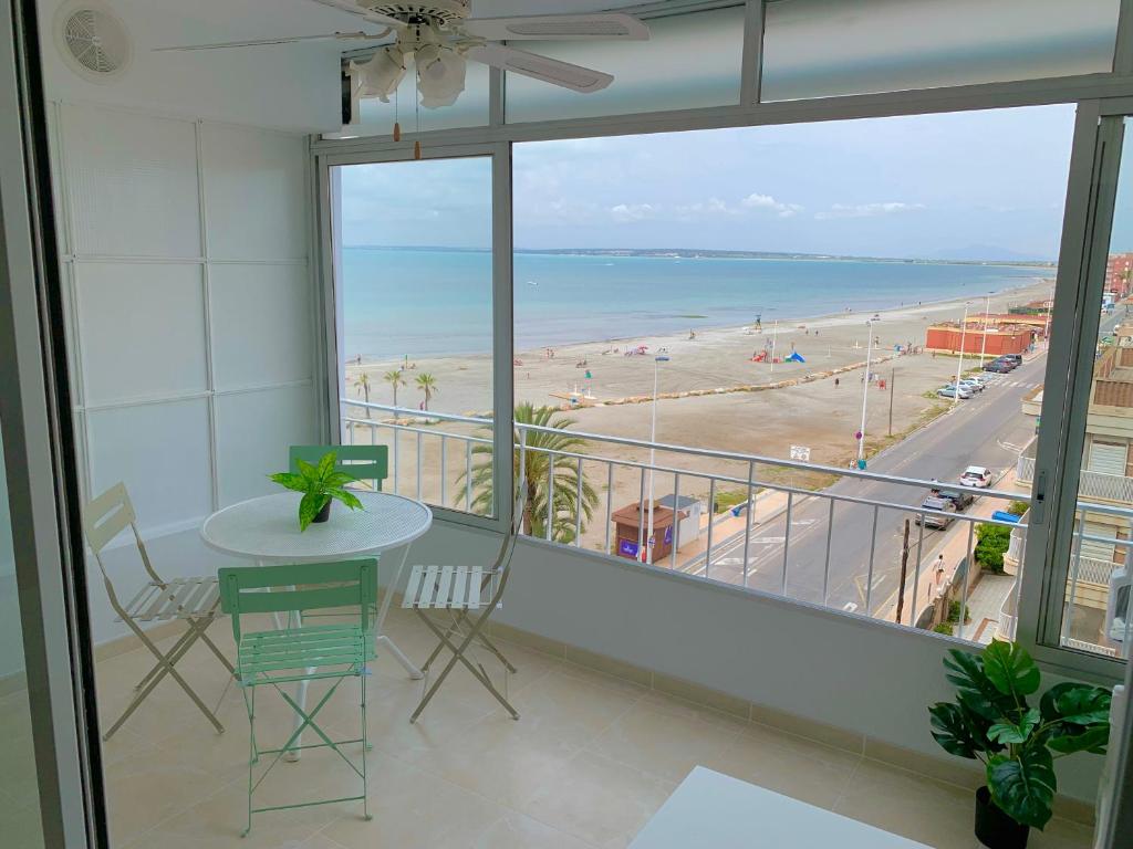 a balcony with a table and a view of the beach at Sunny Beach Retreat in Santa Pola