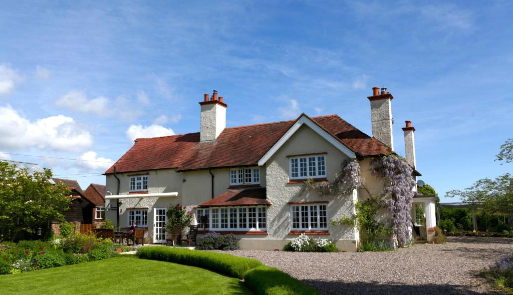 een groot wit huis met een rood dak bij Church Farm B&B near Telford and Ironbridge in Shifnal