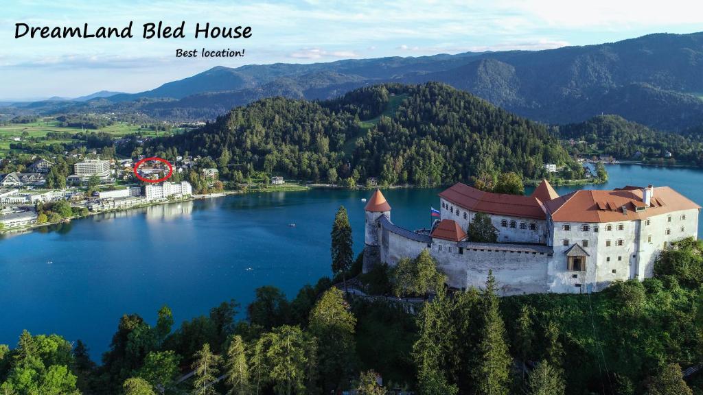 an aerial view of a castle on the edge of a lake at DREAMLAND BLED Apartments in Bled