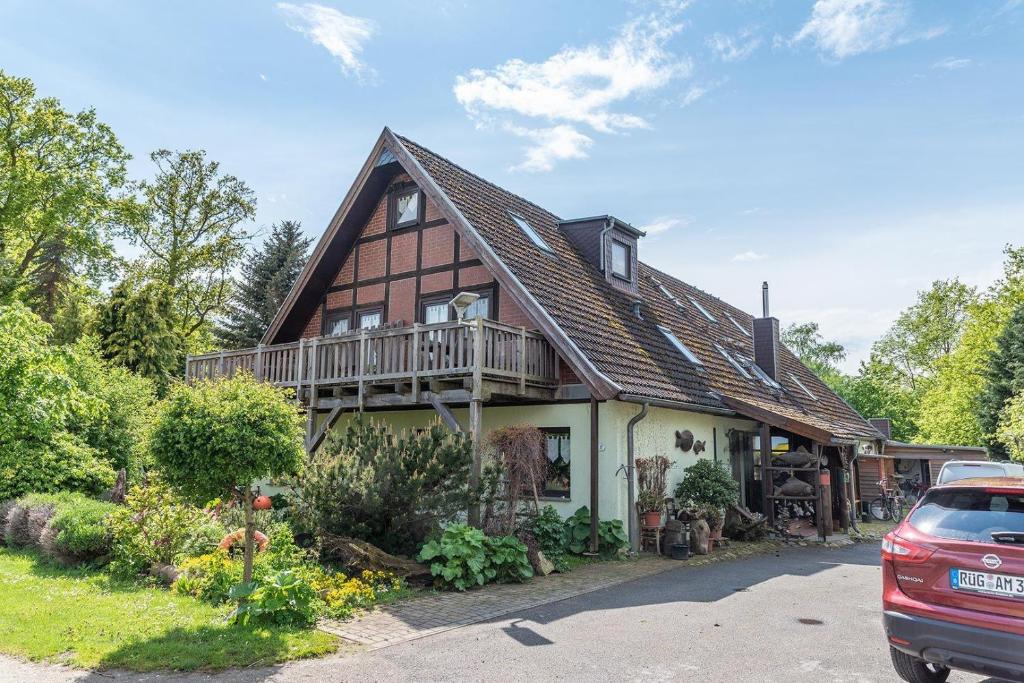 ein Haus mit einem Balkon und einem Auto vor dem Haus in der Unterkunft 3 Raum FeWo auf Rügen für 4 Personen in Schaprode