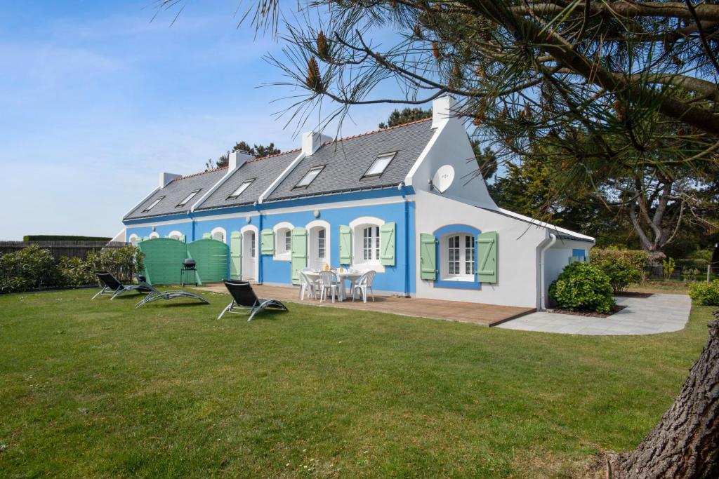 a blue and white house with a yard at Maison charmante à Bangor avec jardin et cheminée in Bangor