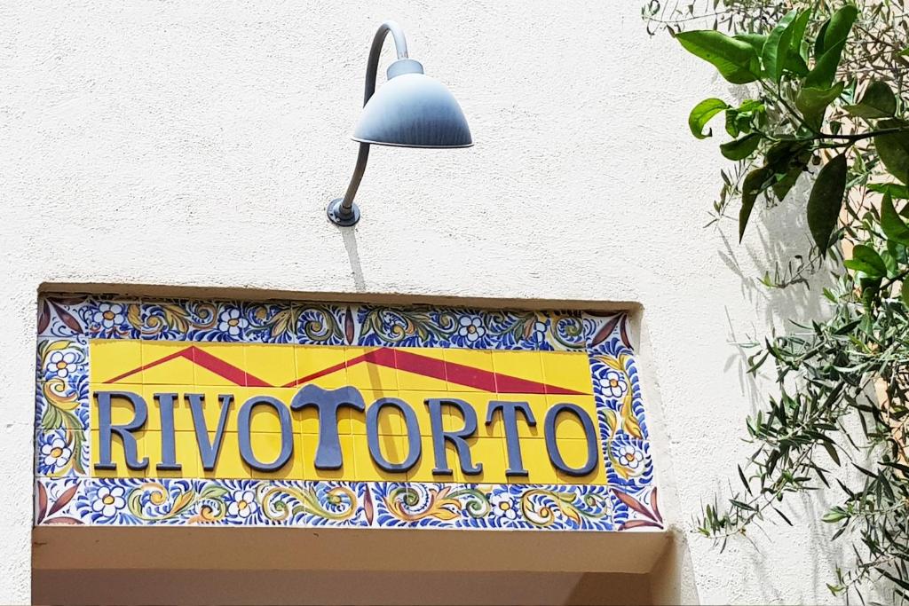 a sign on the side of a building with a lamp at Rivotorto Retreat House in Birkirkara