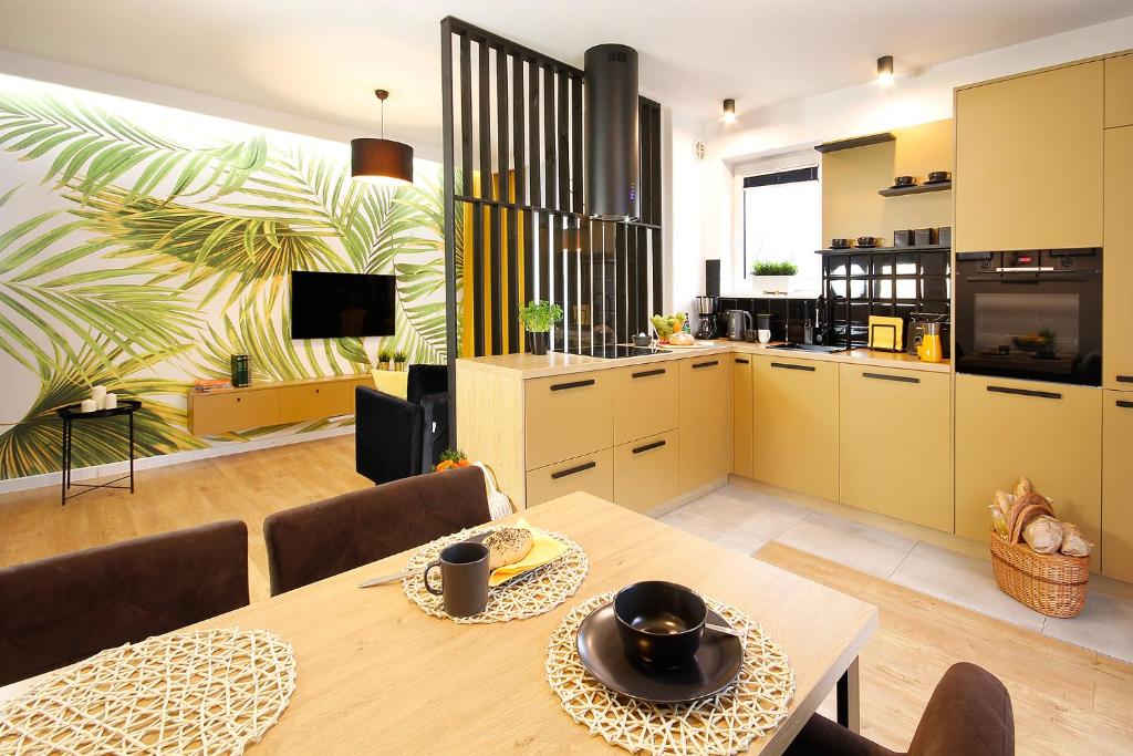 cocina y comedor con mesa y sillas en W&K Apartments - Gold Suite, en Koszalin