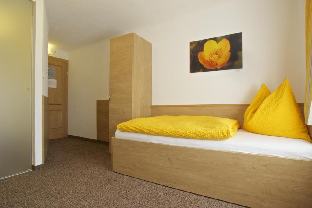 ein Schlafzimmer mit einem Bett mit gelben Kissen darauf in der Unterkunft Gasthof-Hotel zur Linde in Yspertal