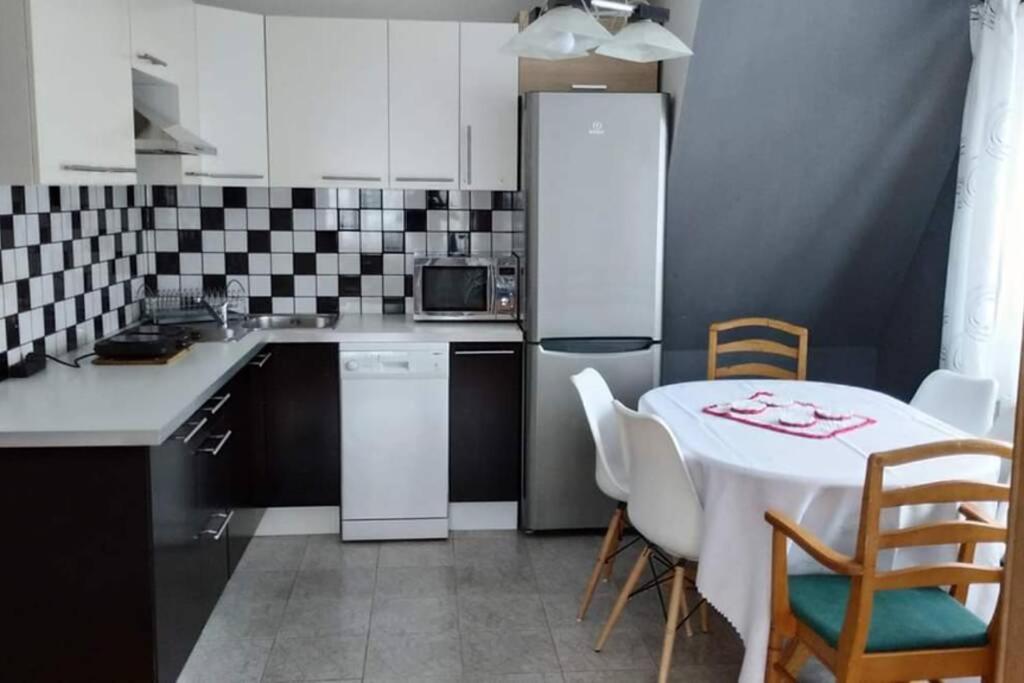 eine Küche mit einem Tisch und einem weißen Kühlschrank in der Unterkunft Gospodarstwo Agroturystyczne U Nos Apartament Bioły in Ratułów