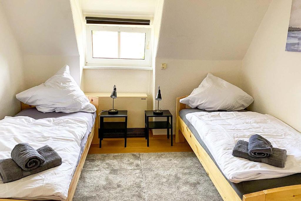 two beds in a small room with a window at Worker Apartments Bernsdorf-Wiednitz in Bernsdorf