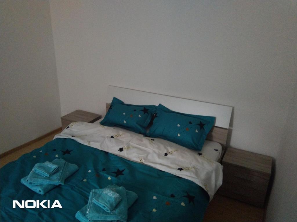 1 dormitorio con 1 cama con sábanas azules y almohadas azules en Cazare, en Deva