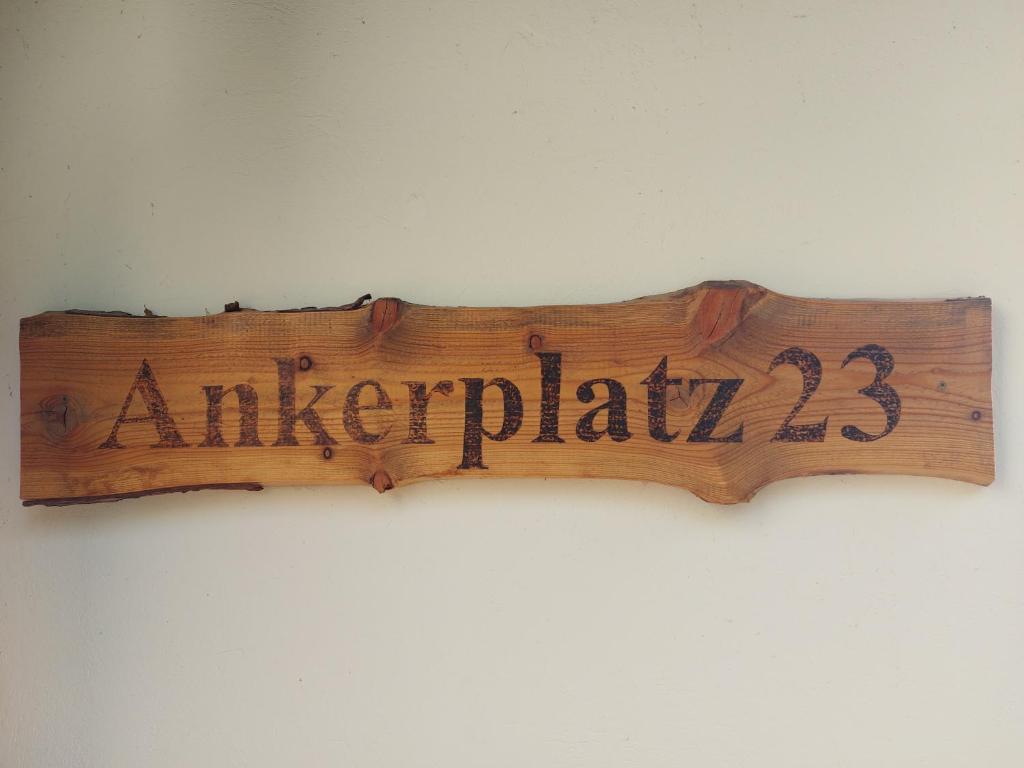 ein Holzschild, das an einer Wand hängt in der Unterkunft Ankerplatz 23 in Ostseebad Sellin