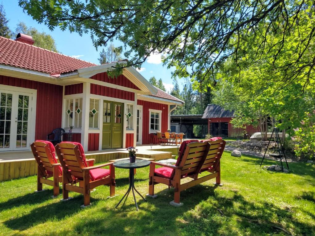 een huis met stoelen en een tafel in de tuin bij Stuga Glaskogen in Glava