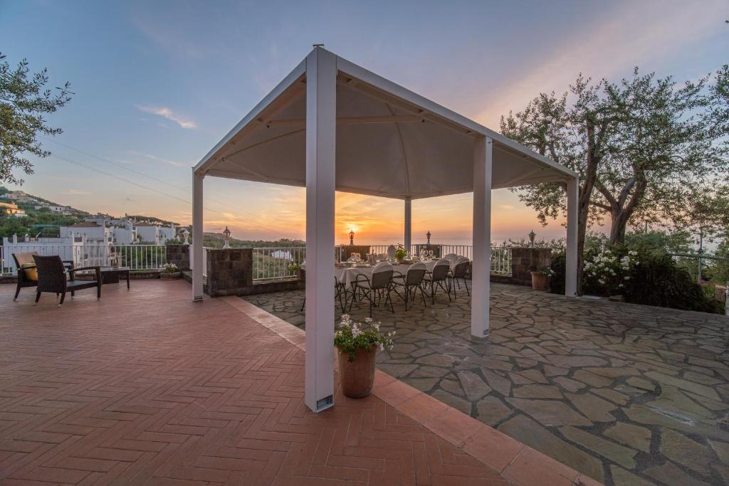 a pavilion with tables and chairs on a patio at Villa Carolina Sorrento with sea view Jacuzzi and Pool in Sorrento