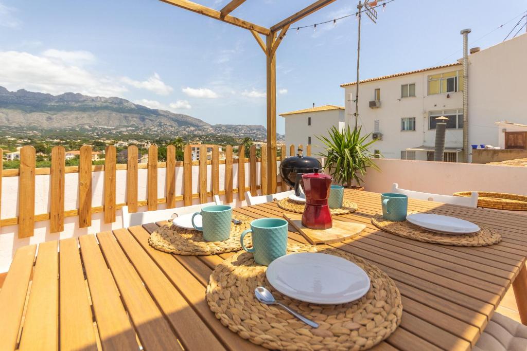 a wooden table with plates and cups on a deck at Wonderful Views Terrace 3BR Cottage - BBQ - AC in Altea