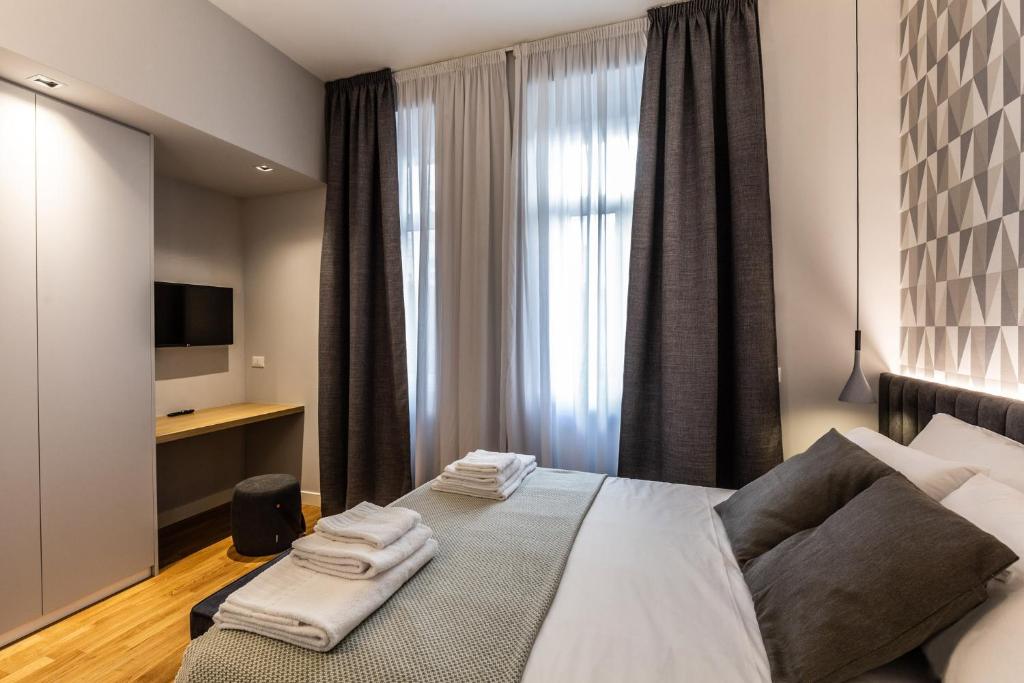 a bedroom with a large bed with towels on it at CA’MILLA Luxury Apartments Trieste in Trieste