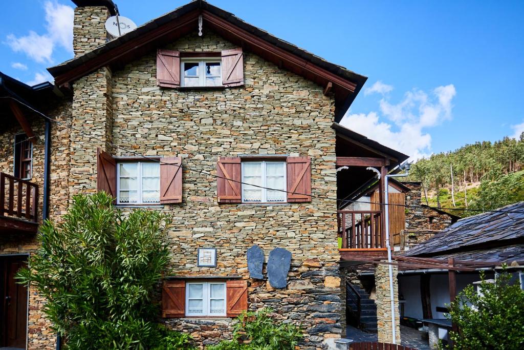 Cette ancienne maison en pierre possède des fenêtres sur le côté. dans l'établissement Cottage da Paradinha: Passadiços do Paiva - Arouca, à Paradinha