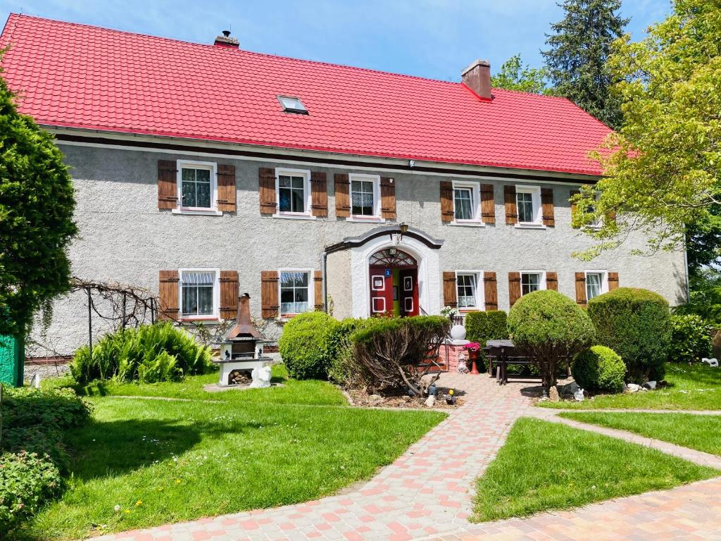 a house with a red roof and a garden at Agroturystyka u Strażaka in Świeradów-Zdrój