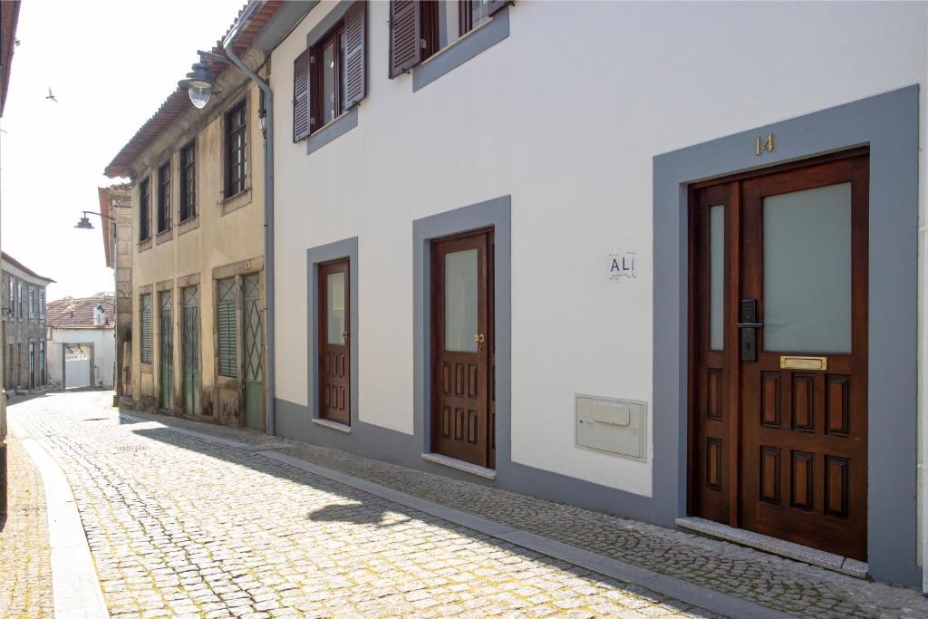 eine Reihe von Türen in einem Gebäude auf einer Straße in der Unterkunft Casa Marialva in Arouca