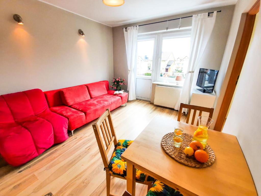 弗瓦迪斯瓦沃沃的住宿－Malmaris，客厅配有红色的沙发和桌子