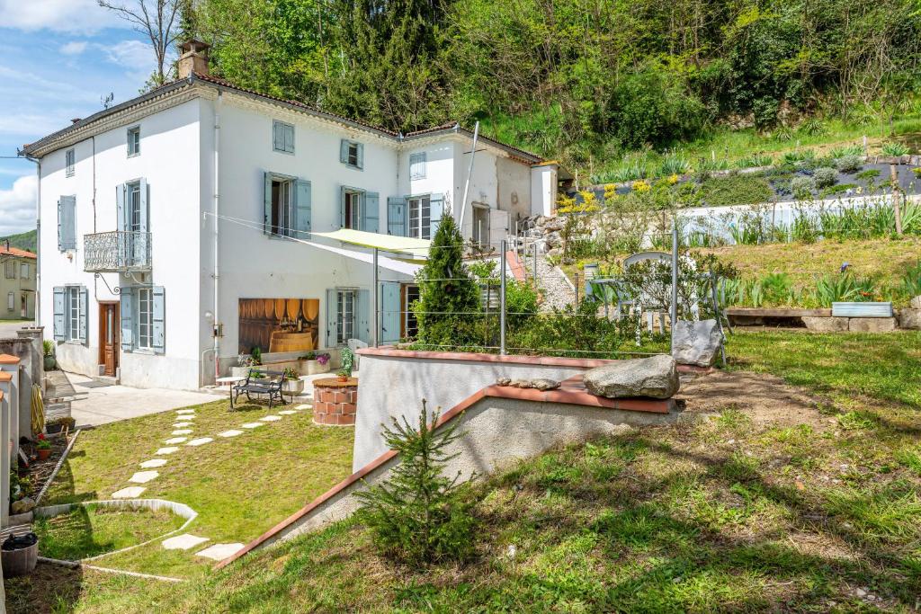 une grande maison blanche avec un jardin en face de celle-ci dans l'établissement Le Mas de la Coupière, à Serres-sur-Arget