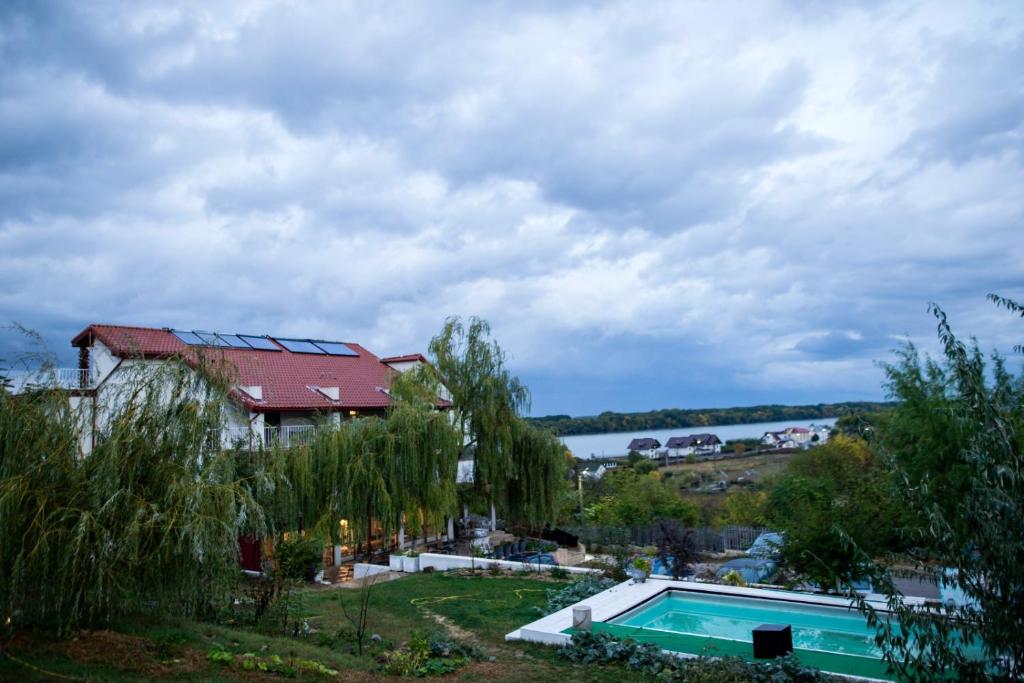 een huis met een zwembad naast een meer bij Pensiunea 4 Salcii in Băltenii de Sus