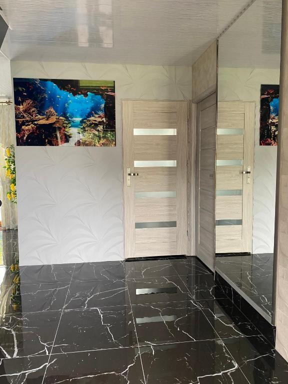 a room with a black marble floor and cabinets at Dom Aurelia in Świnoujście