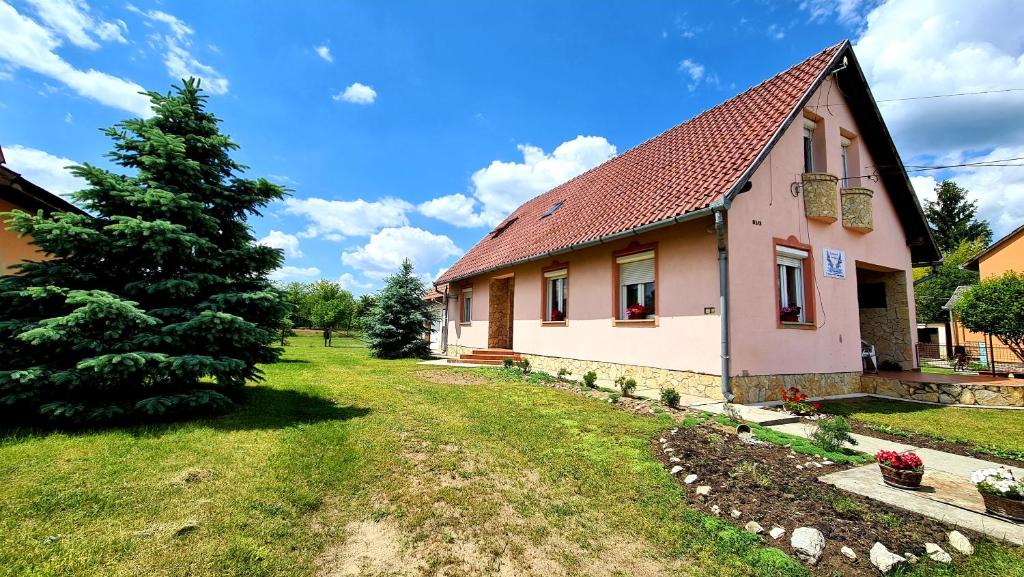a house with a christmas tree in the yard at Veronika Guesthouse in Drávatamási