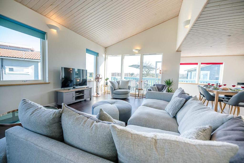 uma sala de estar com um sofá e cadeiras e uma televisão em Stargaze em Great Yarmouth