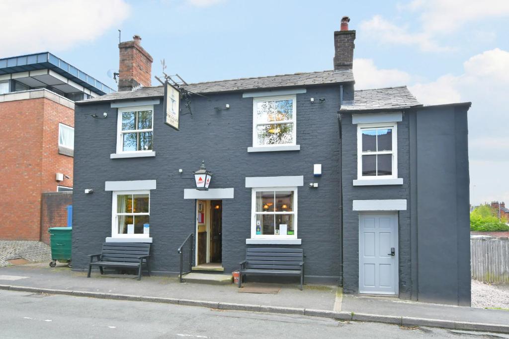 a brick building with two windows on the side of it at The Fountain Inn in Leek