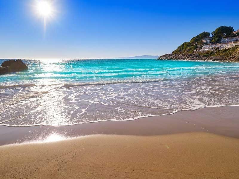 a beach with the ocean and the sun in the sky at 2BD-Piscina-Playa-Port Aventura2 in Salou