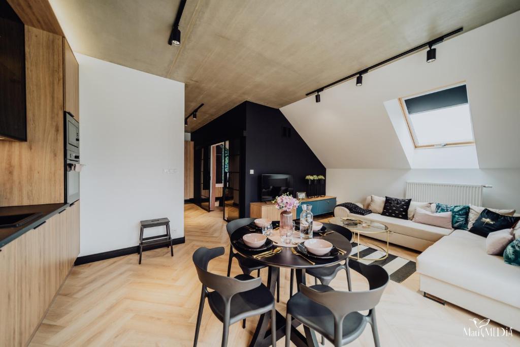 a living room with a table and chairs at Apartament LUX 2 Cieplice in Jelenia Góra