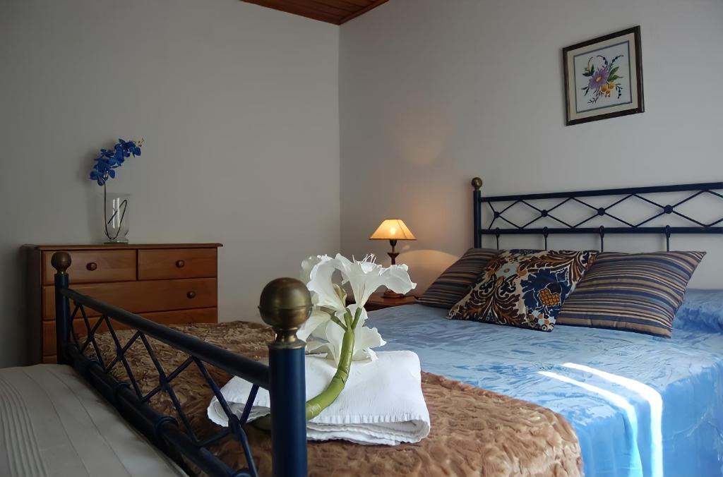 een slaapkamer met een bed met een blauw dekbed bij Mosteiros Sea House in Mosteiros