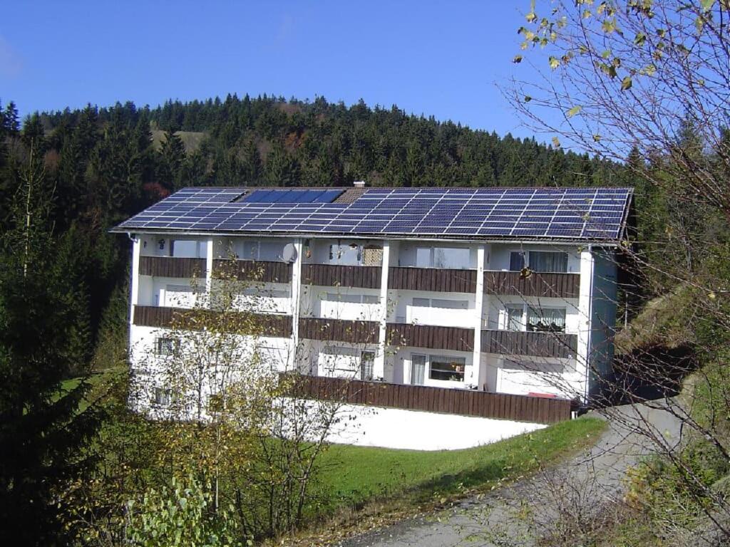 a house with solar panels on top of it at Waldoase-Appartement im Tannenhof in Haidmühle