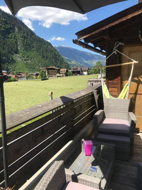 eine Veranda mit einem Stuhl und einem Feld in der Unterkunft Waldhaus Lechner Steinerkogel in Mayrhofen