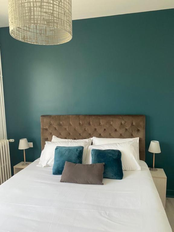 Dormitorio azul con cama blanca y paredes azules en Vue sur Cité - SPA en Carcassonne