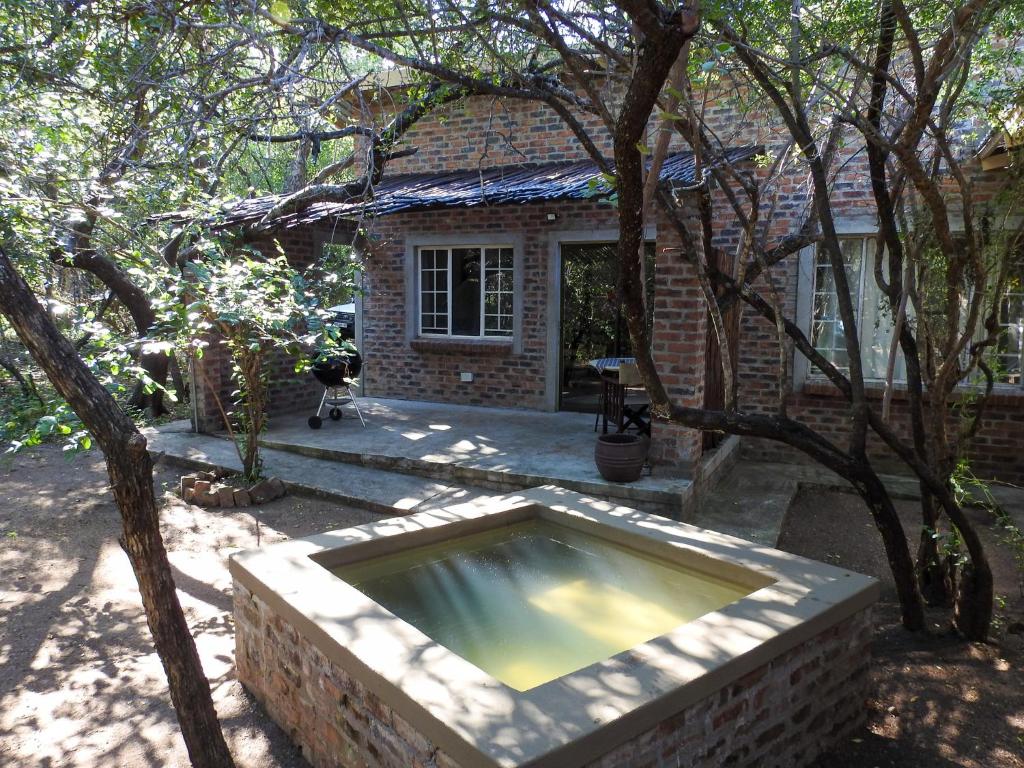 uma casa de tijolos com uma grande banheira em frente em Kruger KayaLakho em Marloth Park